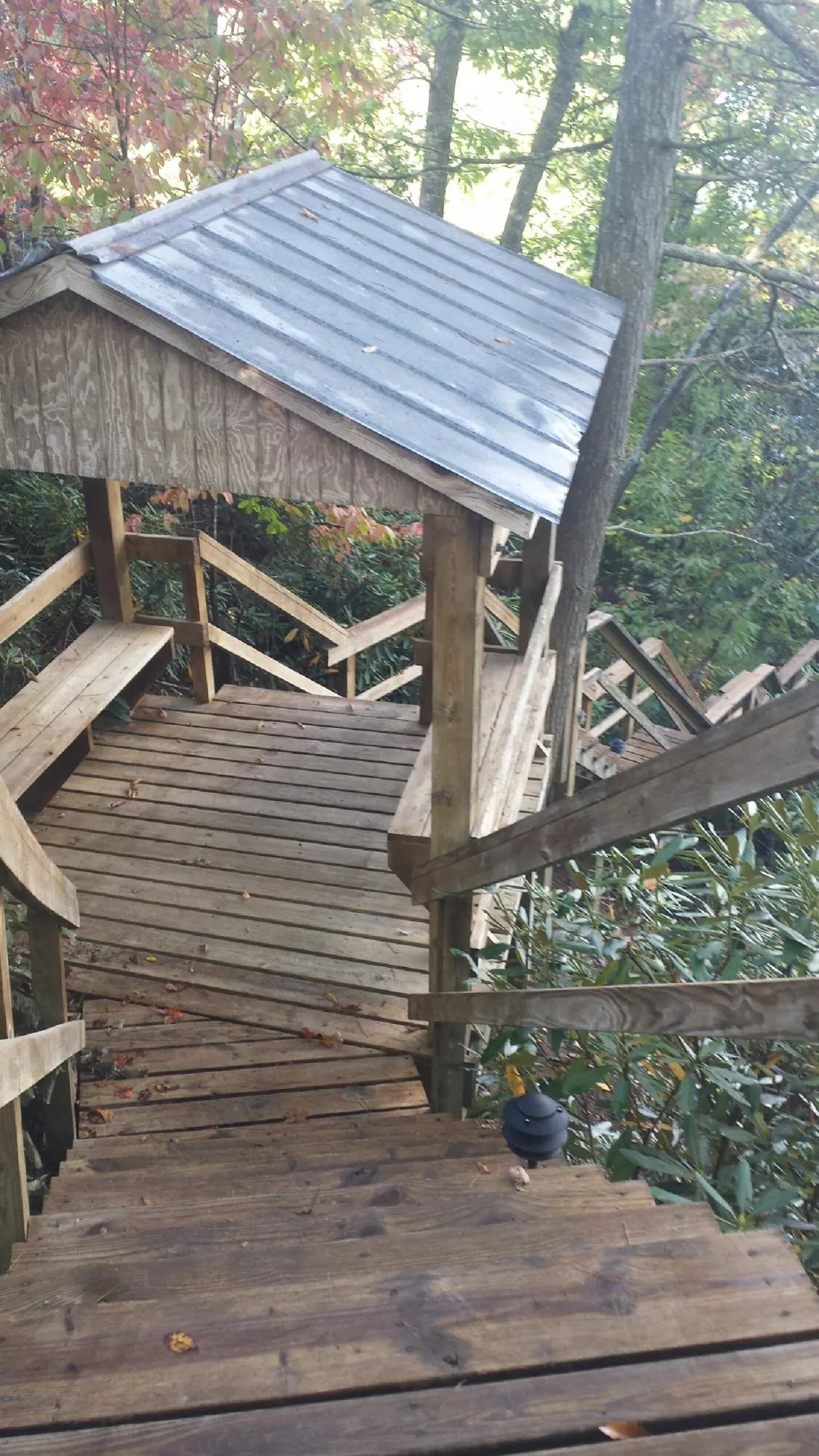 Metal roofed shelter over wooden steps on a wooded walkway — Skylight Repair & Installation work by our crew in Indialantic