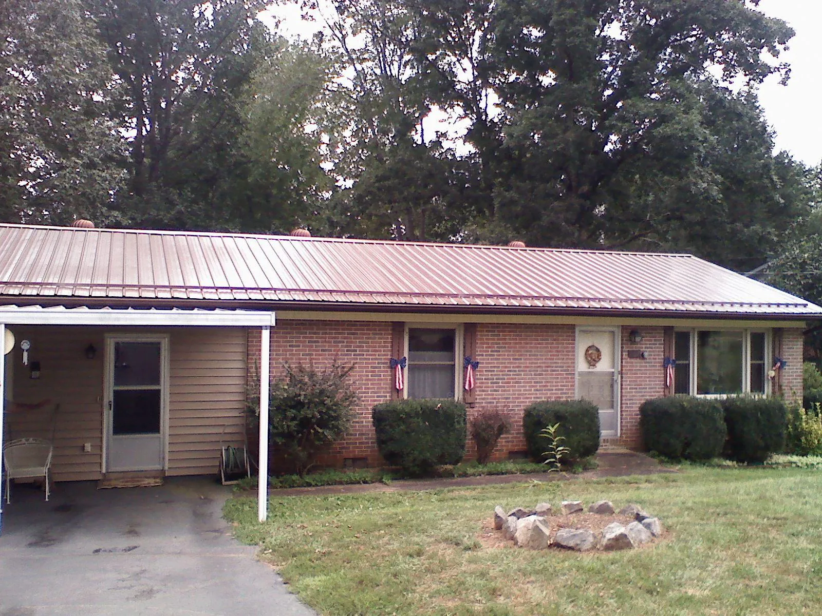 Bronze metal roof and carport on a brick ranch home — Roof Repair work by our crew in Indialantic